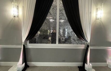 Elegant room with black and white curtains framing a large window.