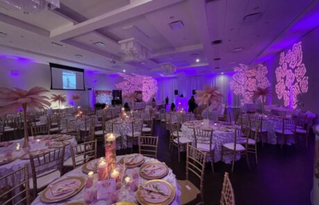 Banquet hall decorated for an event with patterned lighting and guests mingling.
