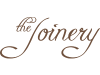 Logo of "the joinery" featuring elegant cursive typography in dark brown color.