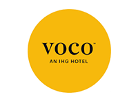 Logo of voco, an ihg hotel, on a yellow background.